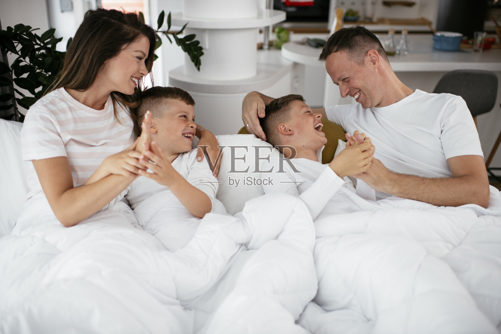 年轻的家庭在床上享受。照片摄影图片