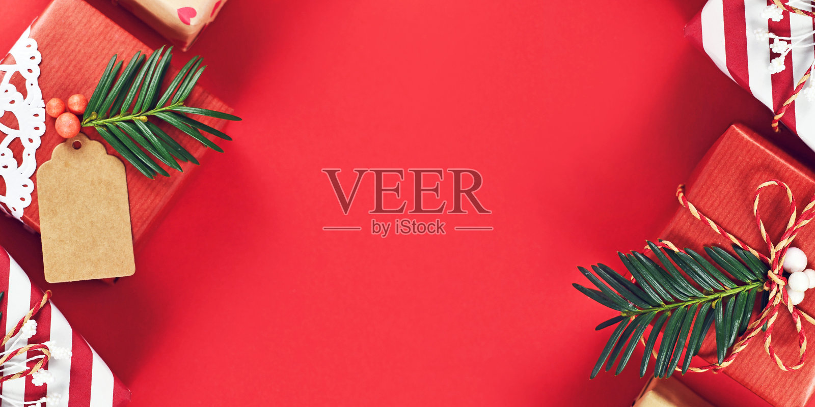 圣诞节横幅与美丽的红色，白色和天然棕色装饰礼盒丝带和杉树枝在红色的背景照片摄影图片