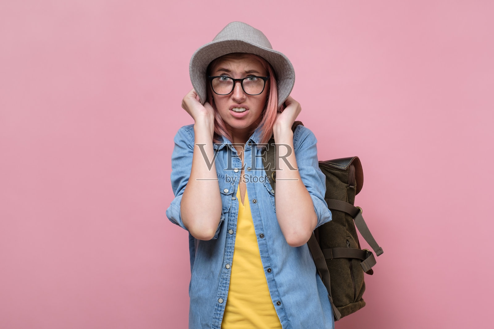 受惊的年轻女子戴着帽子感到惊慌失措。照片摄影图片