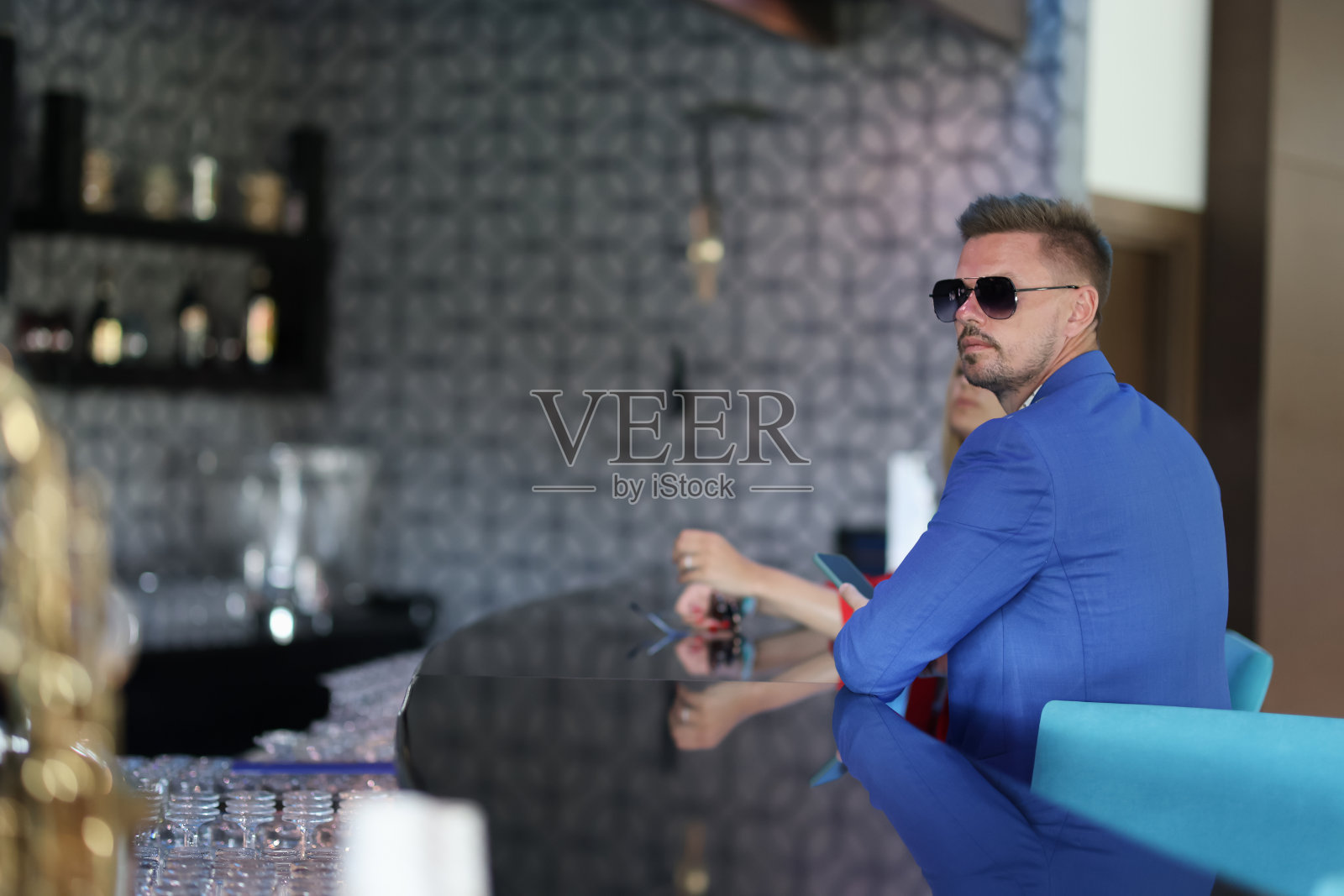 时髦的年轻男子正在酒店的酒吧里等候照片摄影图片