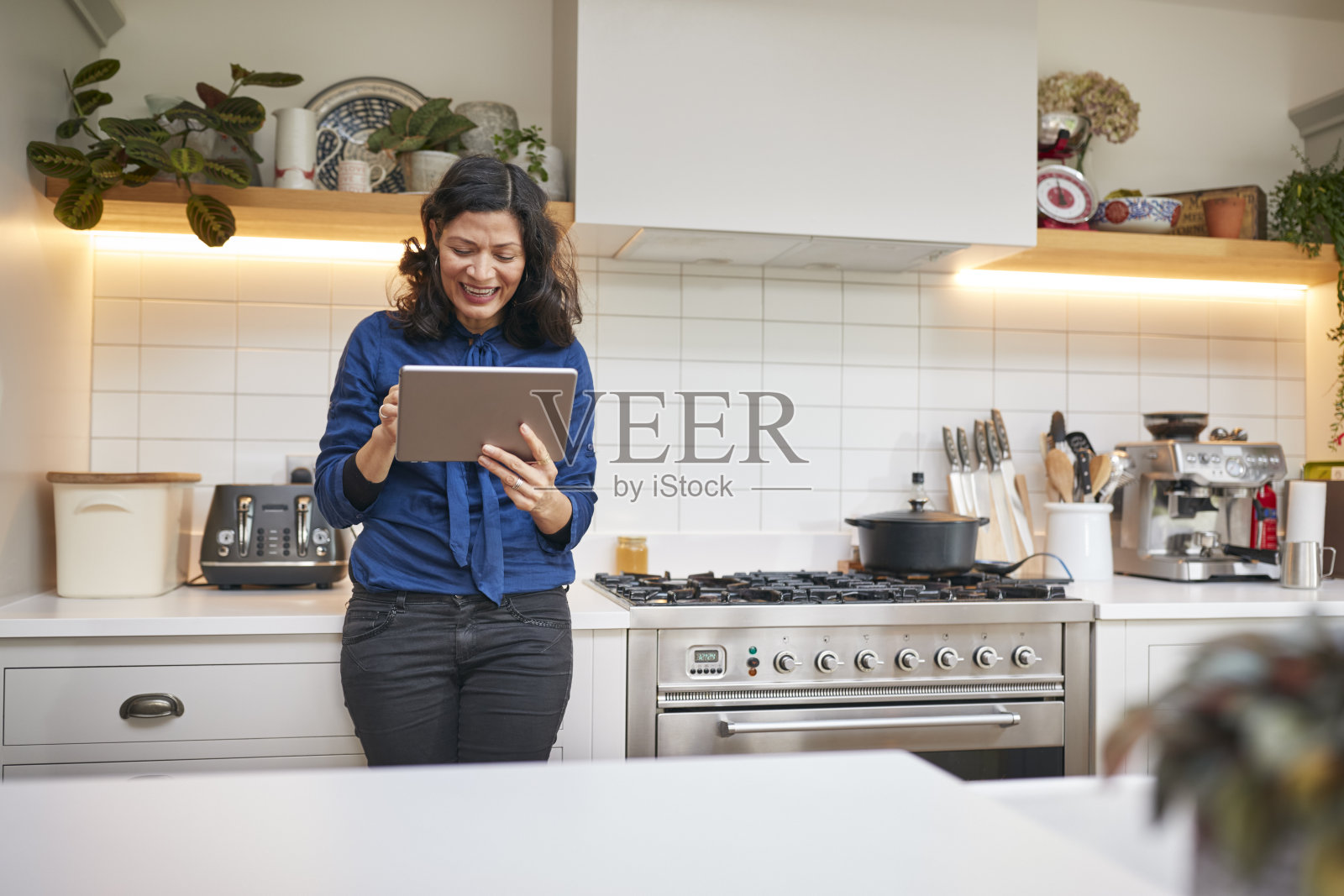 成年女性在厨房看数字平板电脑照片摄影图片