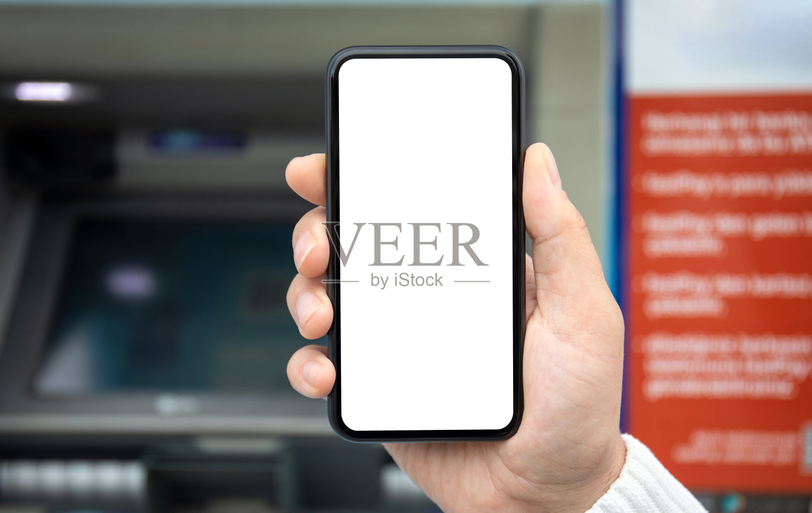 男性手持手机，ATM屏幕背景隔离照片摄影图片