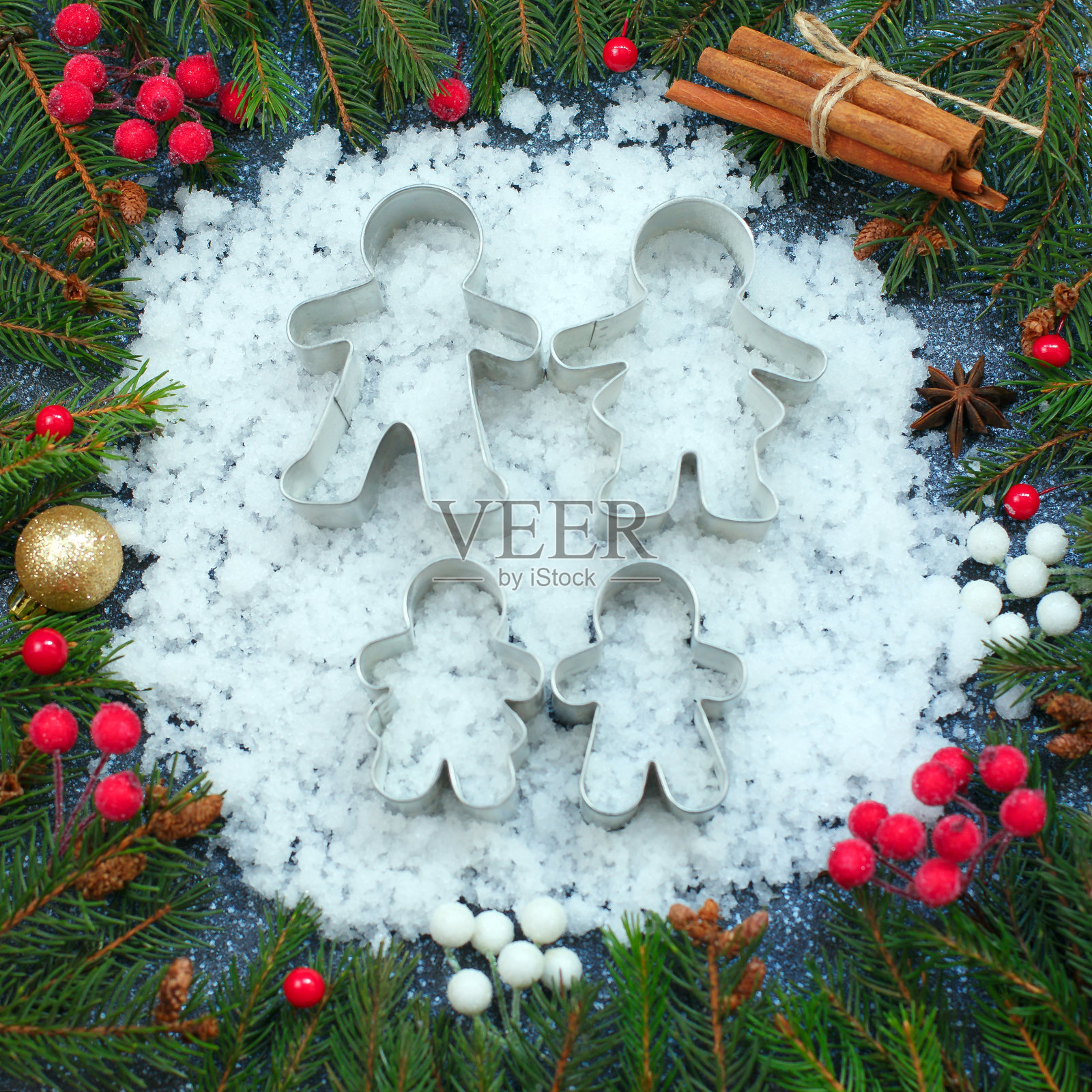 圣诞背景与圣诞树和浆果男性和女性曲奇切割机在中间的雪圣诞贺卡，框架，横幅。寒假主题。新年快乐。照片摄影图片