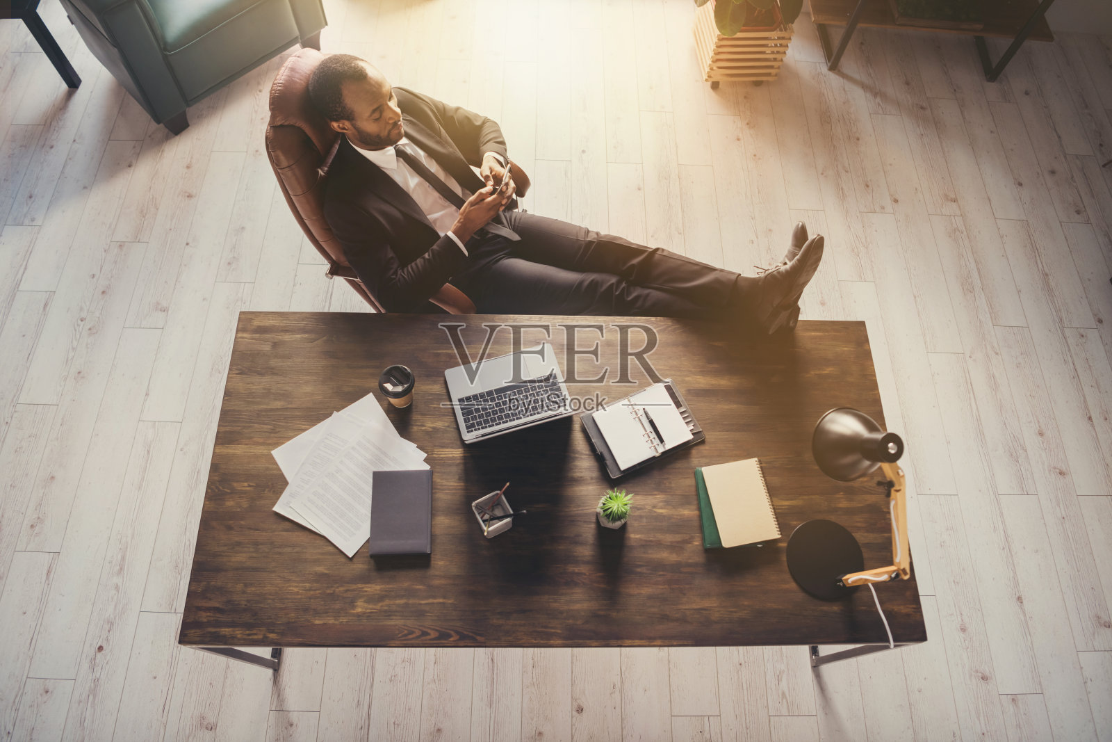 在高处俯瞰他，他，他，漂亮迷人，优雅别致，冷静平和的家伙，金融家，首席执行官，老板，首席执行官，首席执行董事，坐在椅子上，用设备在工作地点，工作站聊天照片摄影图片