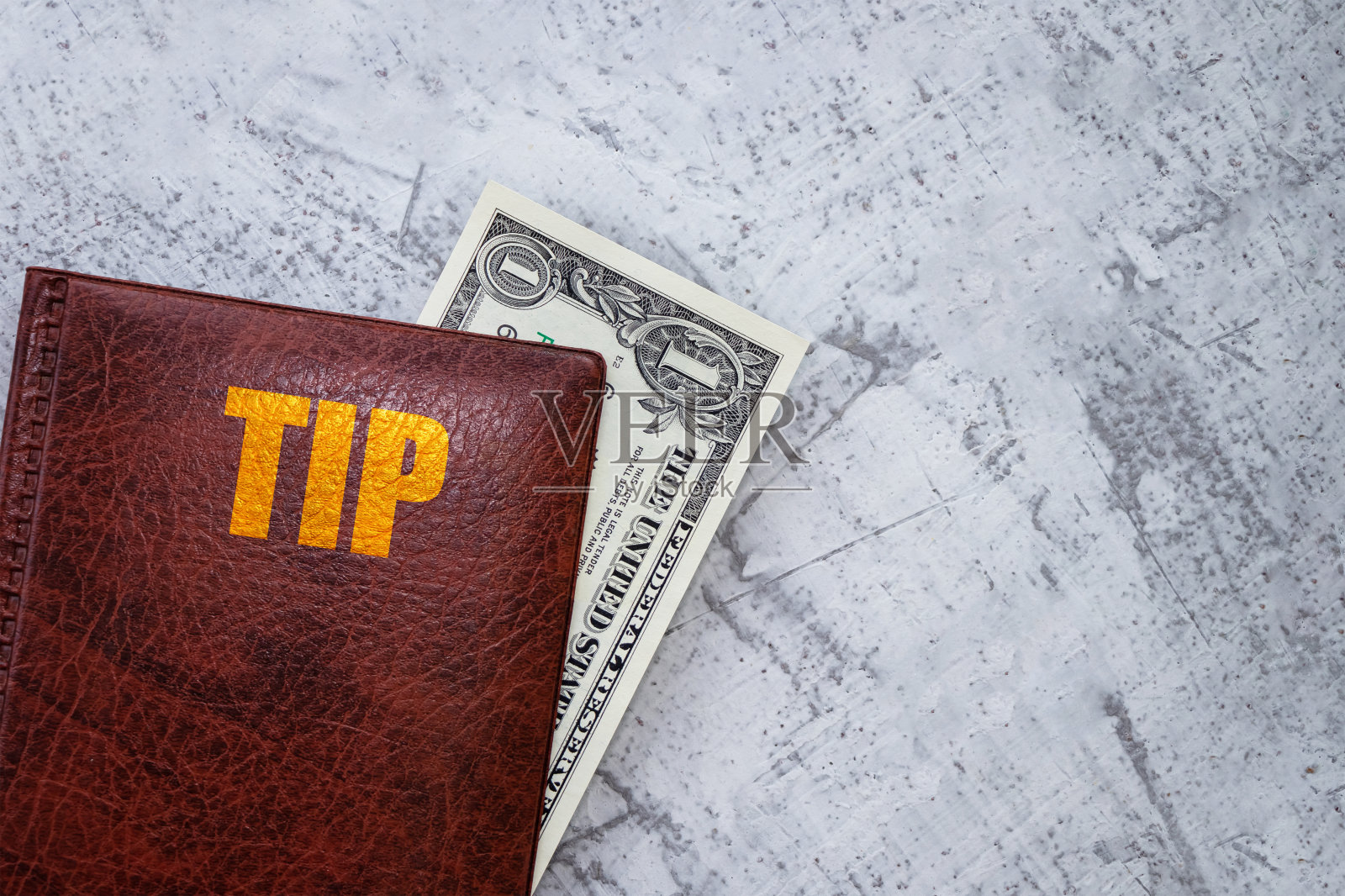 一张美钞躺在封面上，上面写着:小费。文件夹里有一美元。提示的概念。照片摄影图片