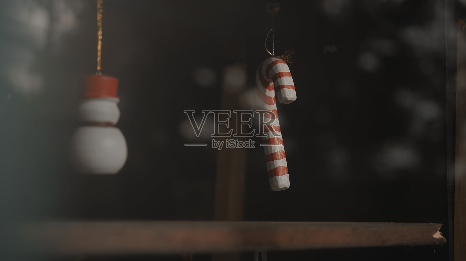 圣诞装饰品糖果拐杖挂在玻璃后面的房子照片摄影图片