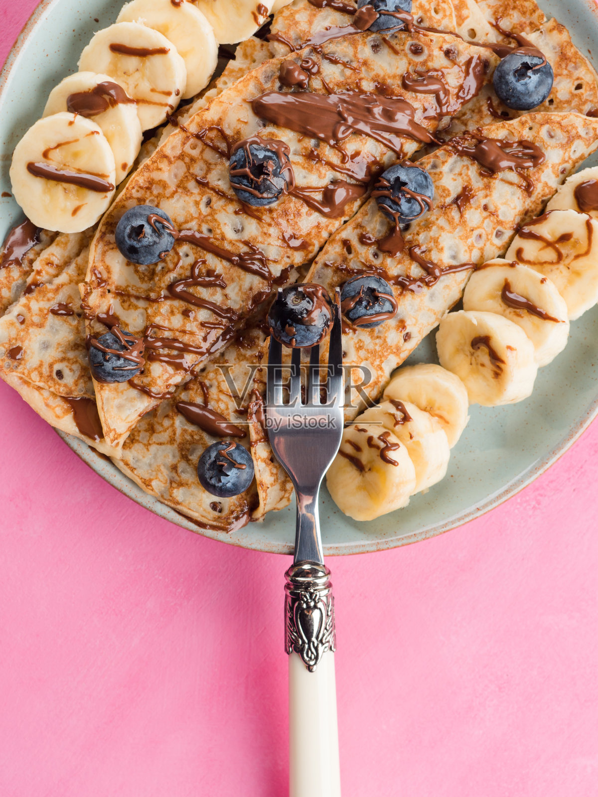 可丽饼配巧克力坚果，香蕉，浆果照片摄影图片