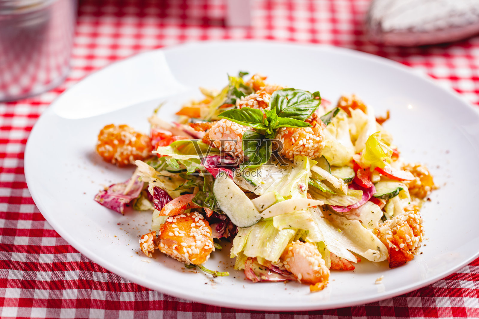 白盘子里的沙拉配三文鱼、蔬菜和各种绿色蔬菜。近距离照片摄影图片