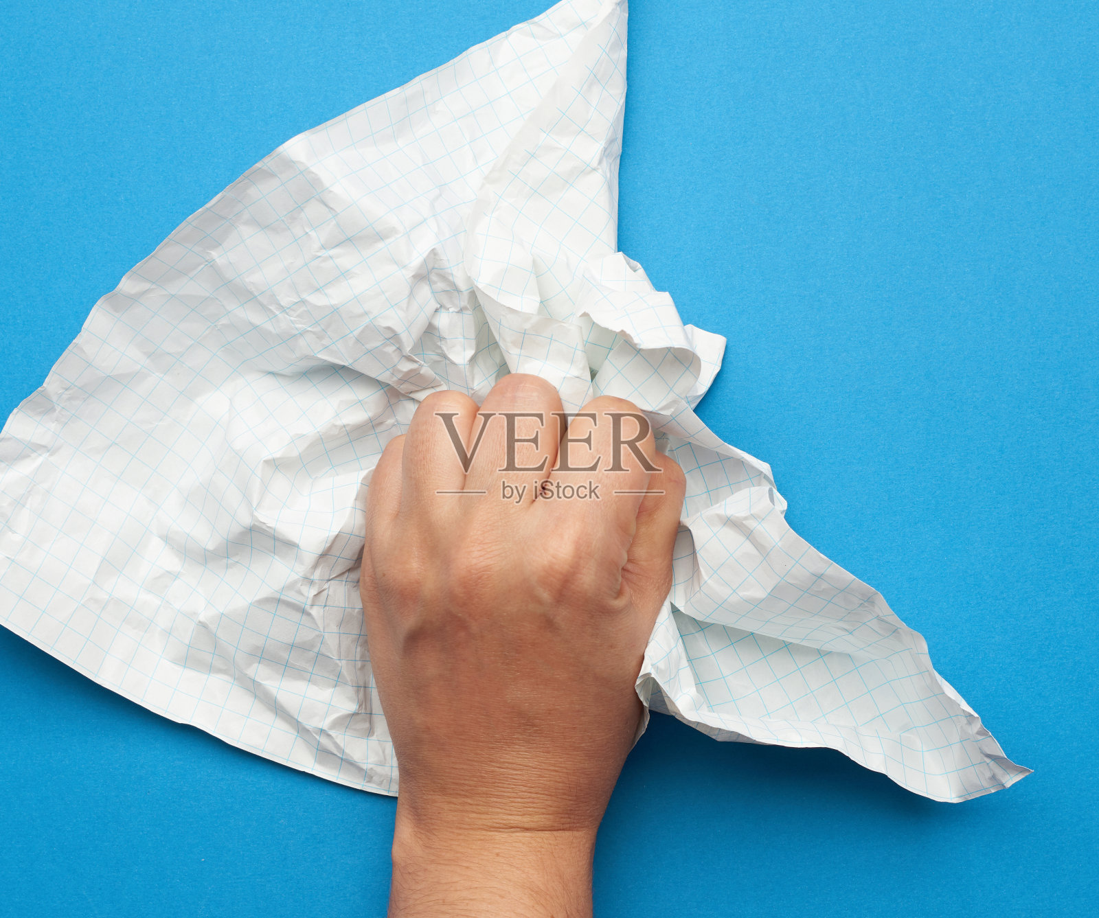 一个女人手里拿着一张皱巴巴的纸，放在一个蓝色背景的笼子里，照片摄影图片