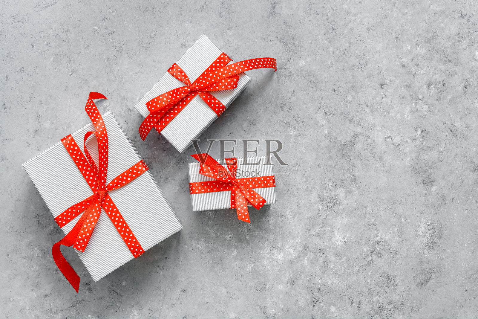 一套礼品盒与红色丝带在灰色垃圾背景。俯视图，平放，复制空间。照片摄影图片