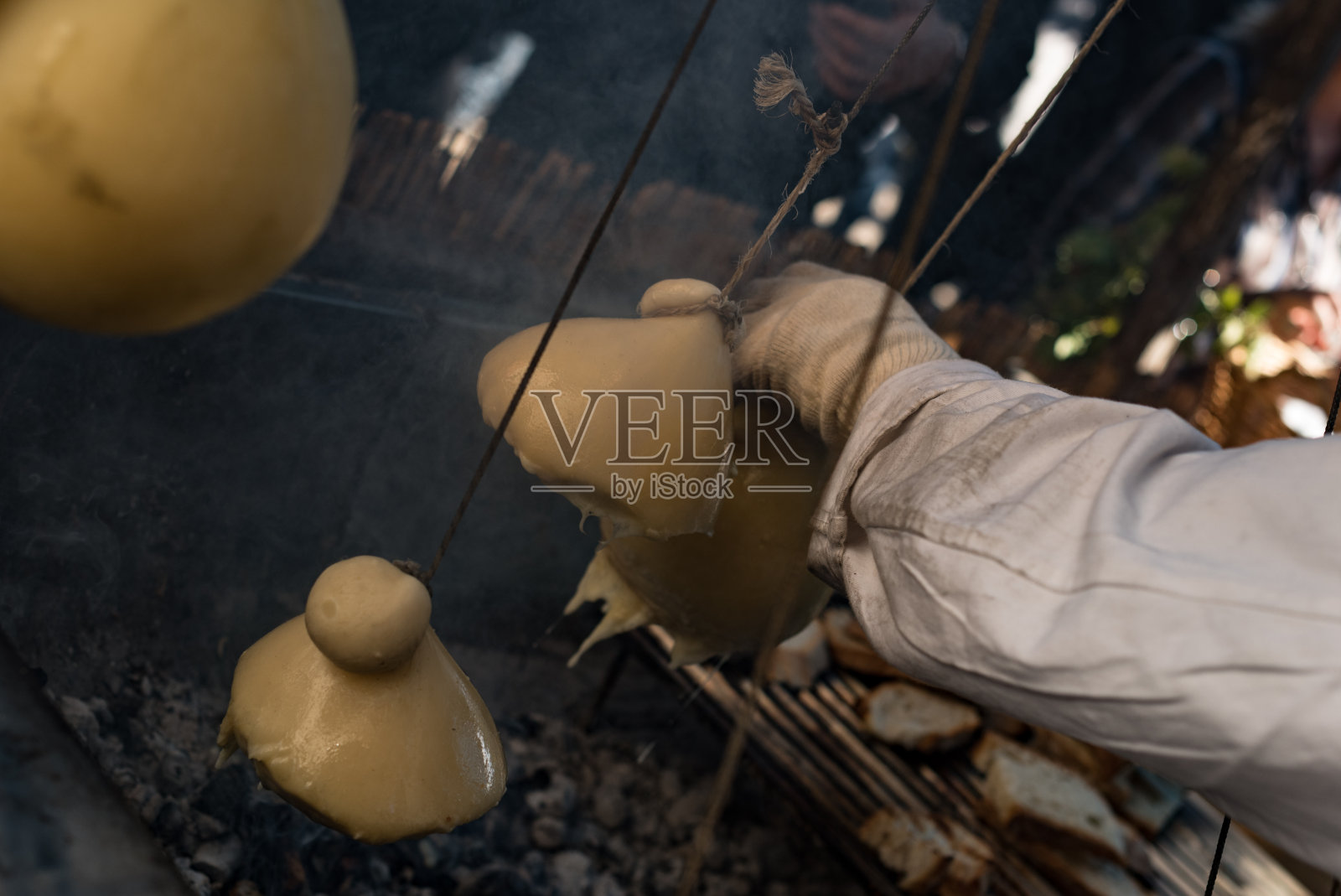 意大利街头食品。在坎帕尼亚小镇蒙特拉的集市上，Caciocavallo在烤架上融化了。Caciocavallo“挂”。栗的节日。特写照片。照片摄影图片