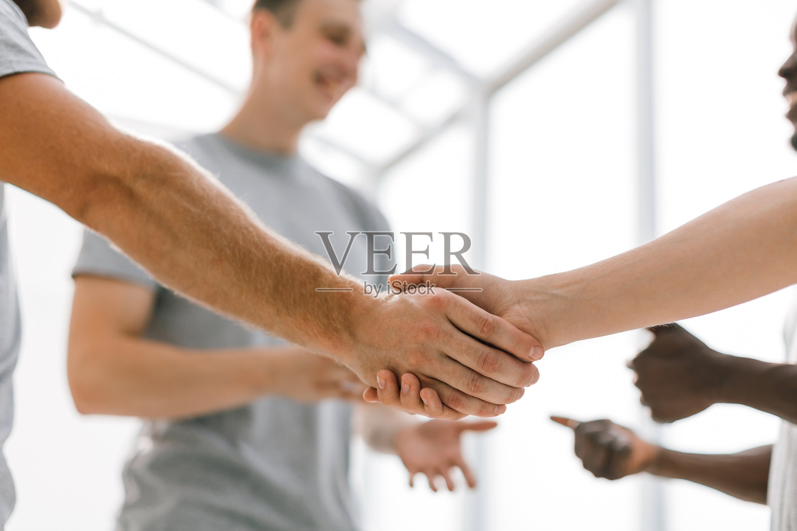 关闭了。两个同志握手，站在一圈朋友中间照片摄影图片