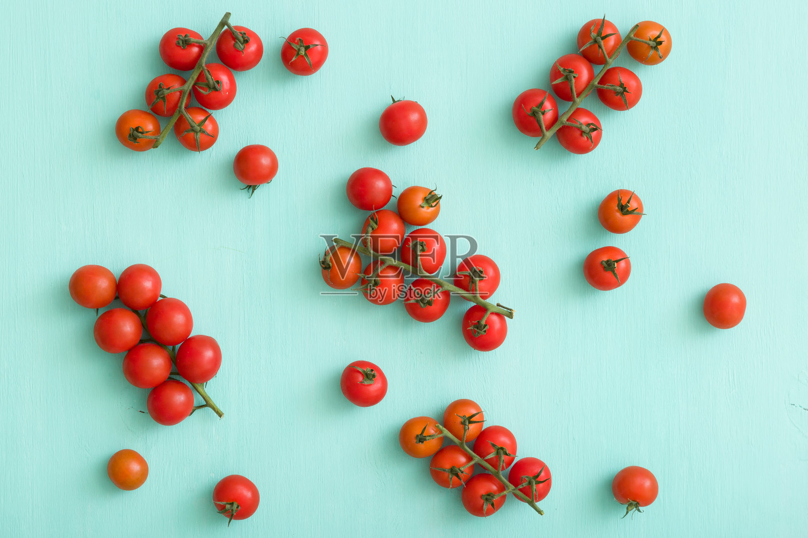 在绿松石木制背景上的有机樱桃番茄特写。照片摄影图片