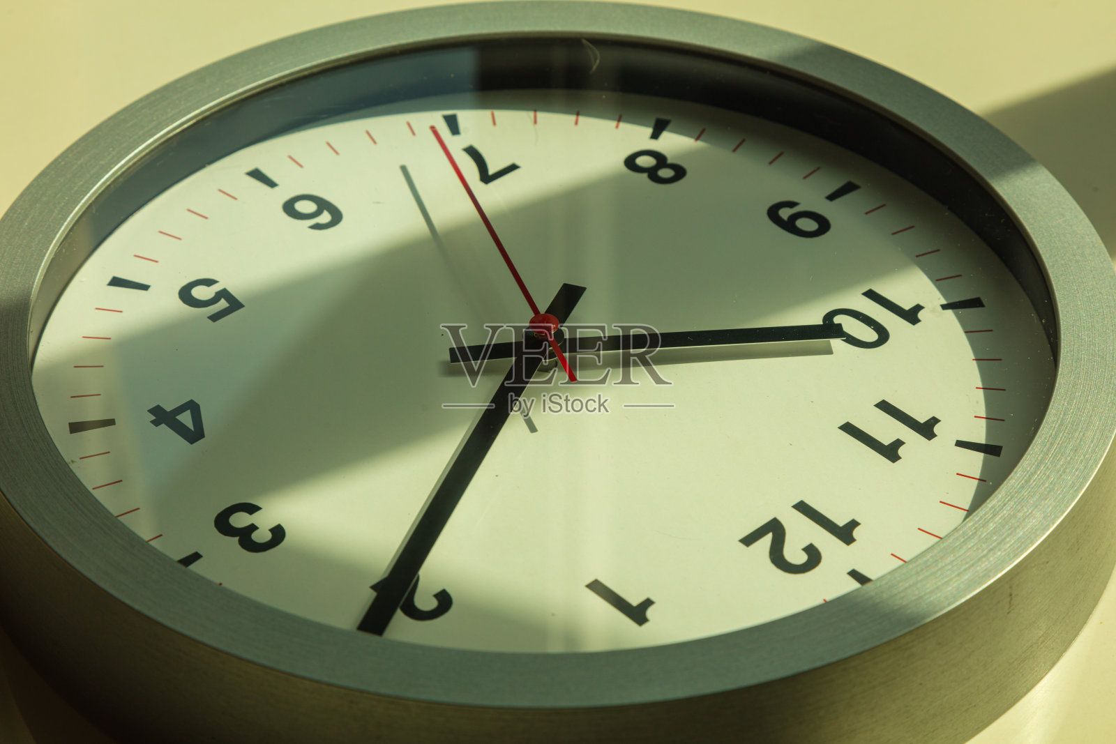 靠近一个挂钟，上面有一个红色的秒针。照片摄影图片