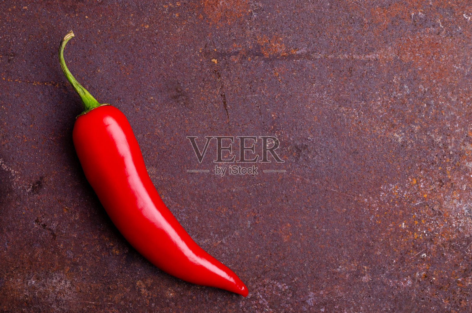 红辣椒荚在生锈的棕色金属背景上。照片摄影图片