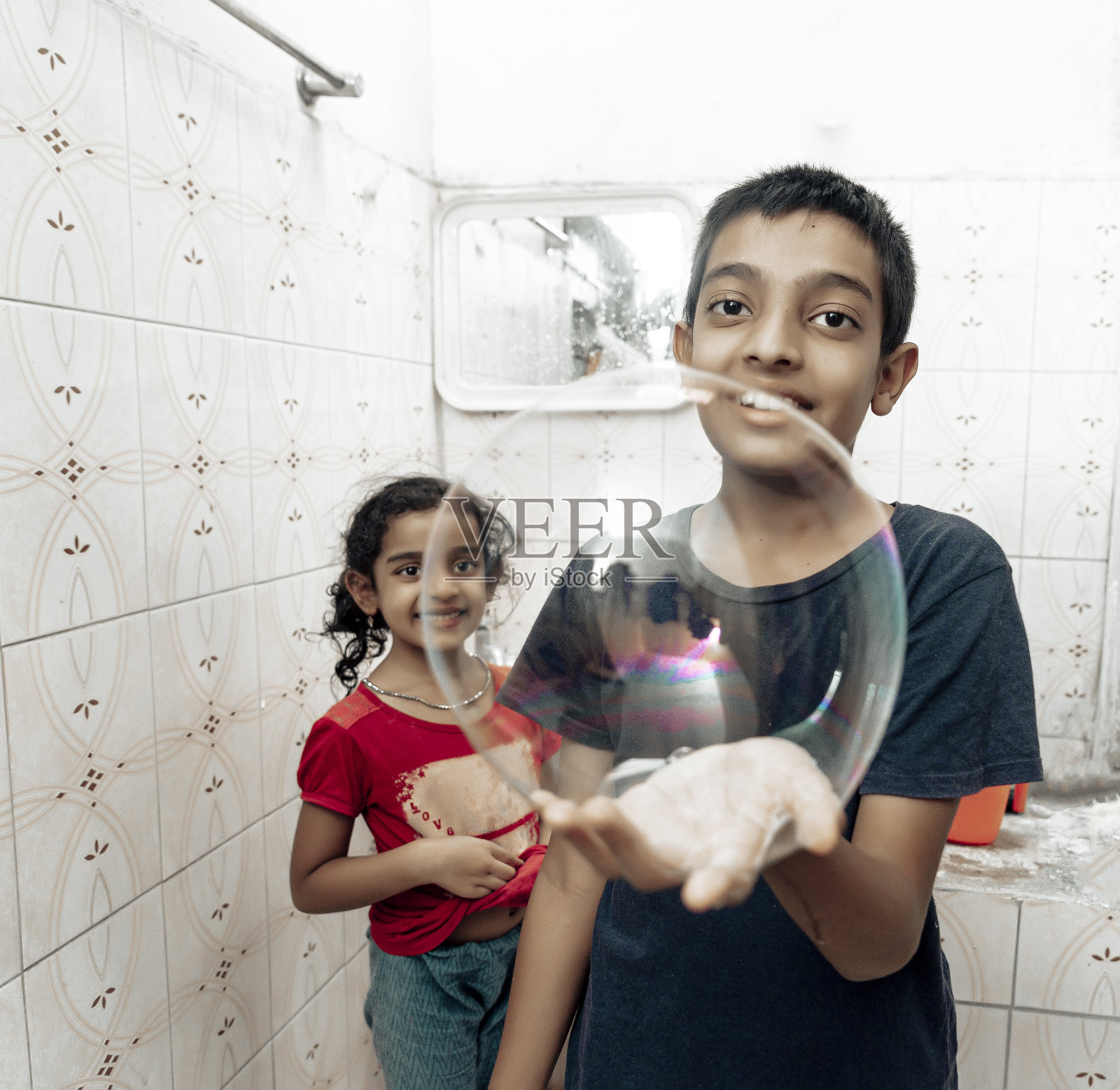 弟弟和妹妹玩肥皂泡泡照片摄影图片
