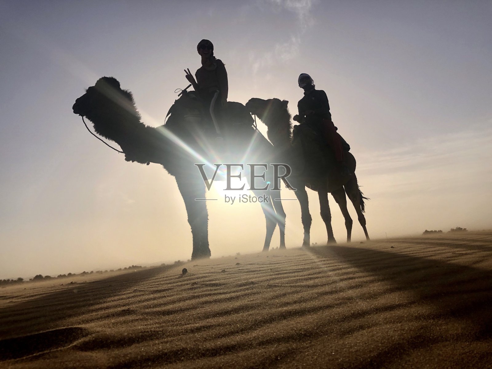 游客在撒哈拉沙漠骑骆驼的剪影照片摄影图片