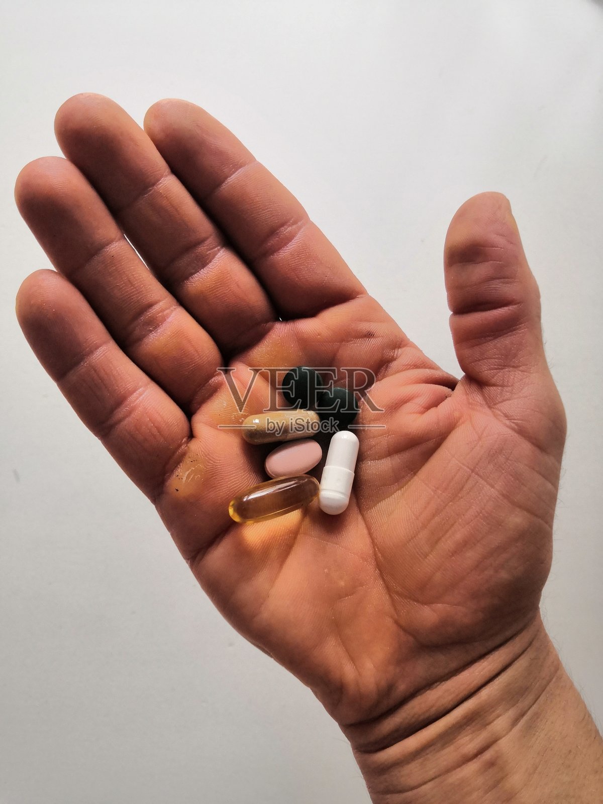 男人的手拿着一些维生素照片摄影图片