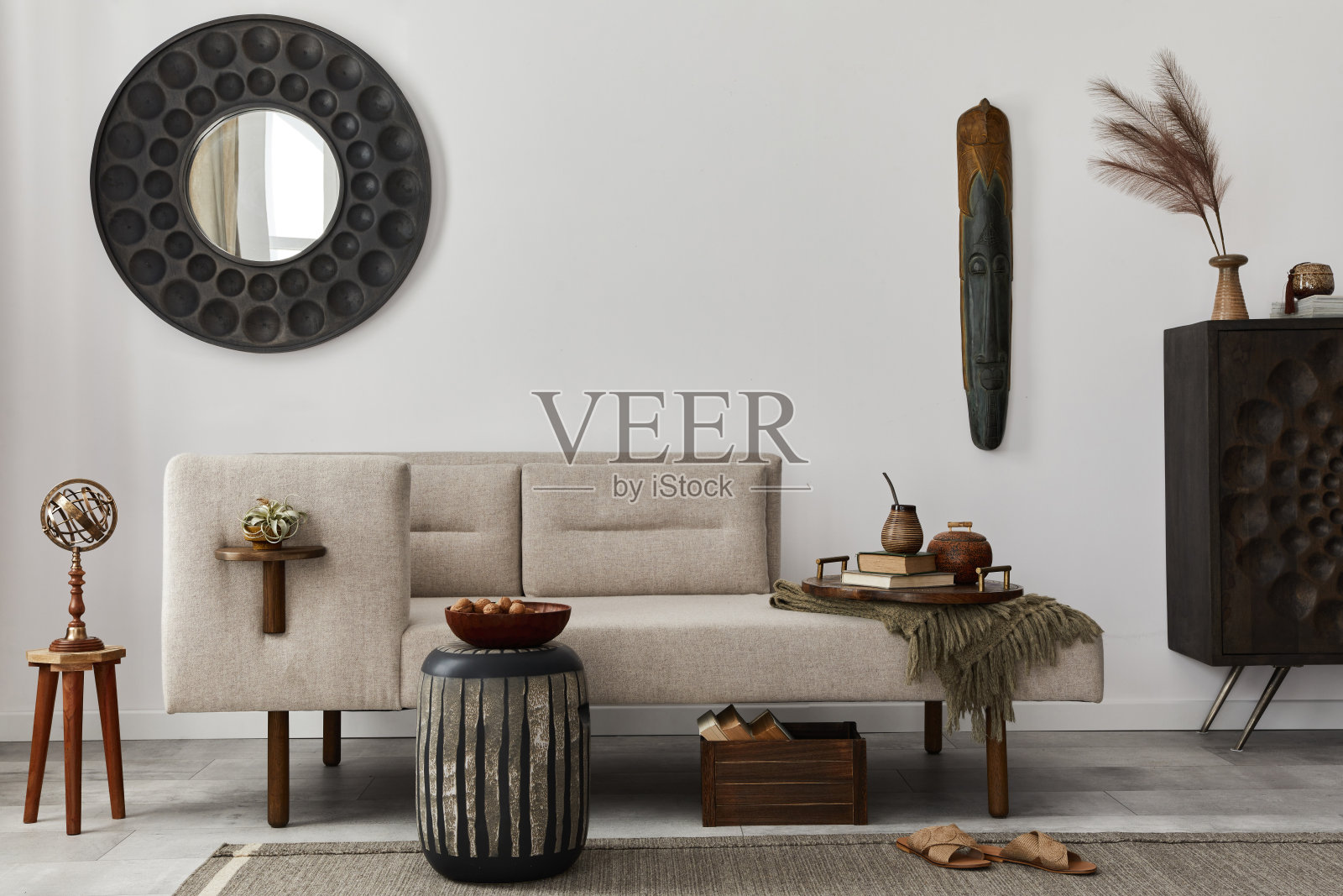 现代民族客厅内饰设计有躺椅、圆镜、家具、地毯、摆设、凳子和高雅的个人饰品。模板。时尚家居装饰。照片摄影图片