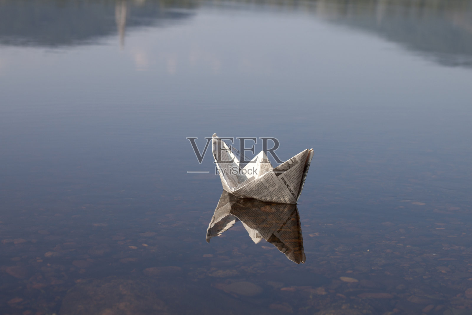 在碧水上航行的折纸帆船照片摄影图片