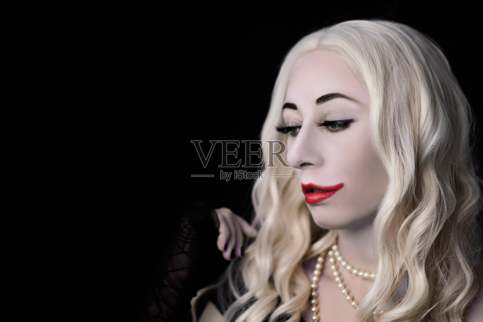 白色头发的女人吸血鬼与绿色的眼睛在一个黑色的背景万圣节照片摄影图片