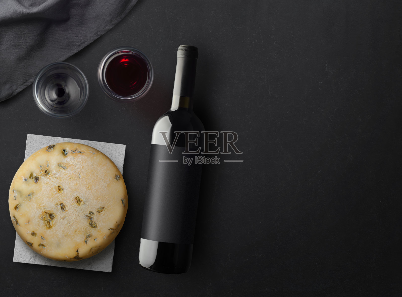 红酒瓶，开瓶器，酒杯，奶酪在黑色的石头背景，俯视图，复制空间。照片摄影图片