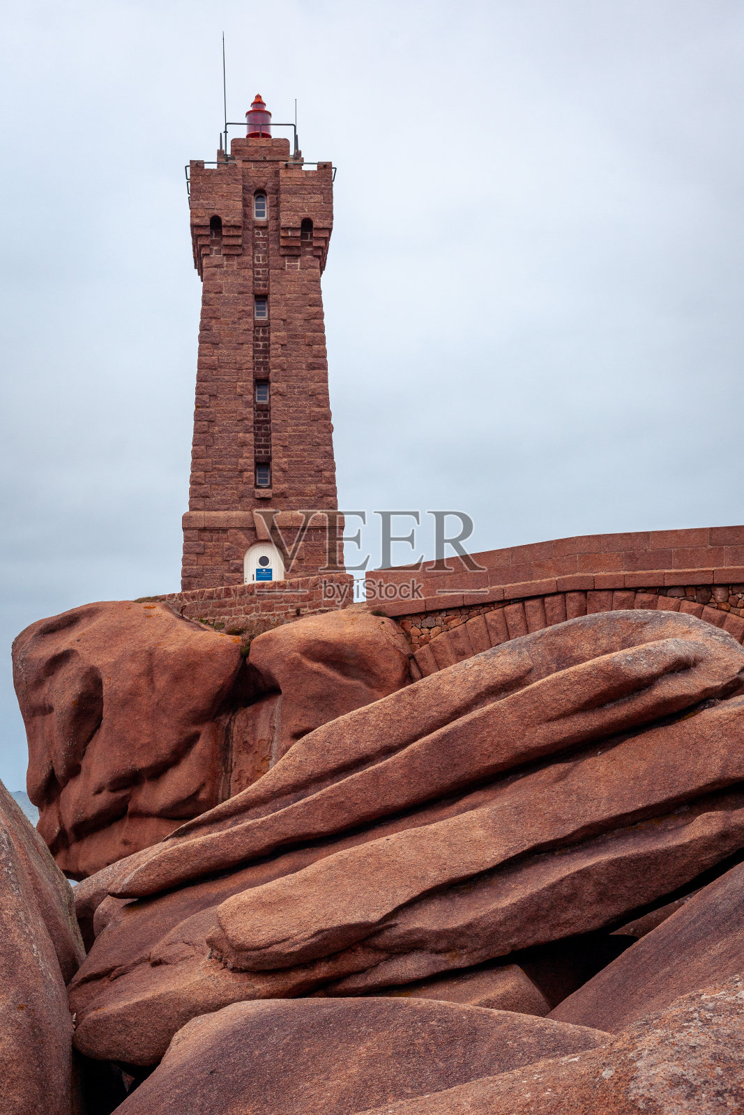 布列塔尼的粉红色花岗岩海岸，可以看到垂直的灯塔照片摄影图片