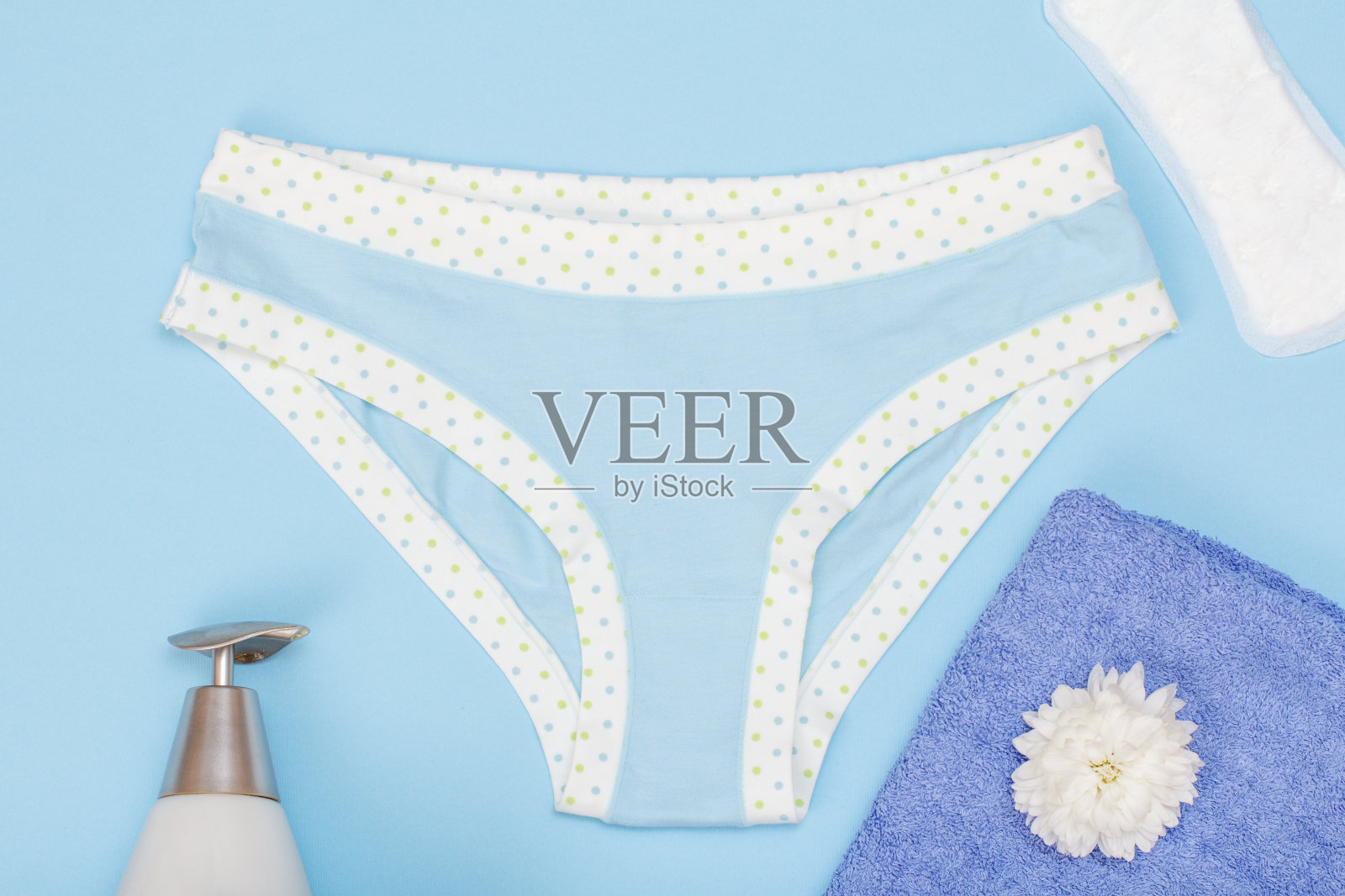 蓝色背景上有卫生巾和毛巾的漂亮女人内裤。照片摄影图片