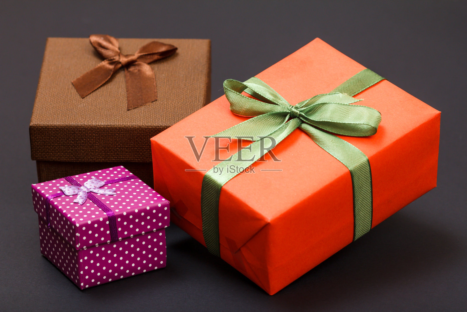 彩带系在黑色背景上的礼盒。照片摄影图片