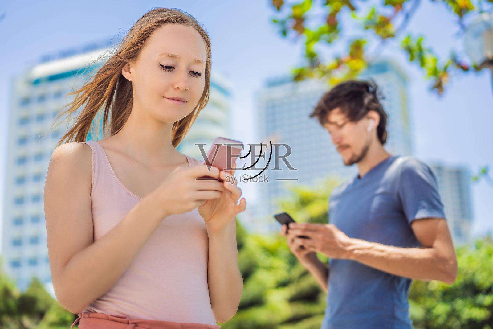 COVID-19大流行冠状病毒移动应用——在城市街道使用智能手机app的戴口罩者，帮助追踪接触者，应对2019-20冠状病毒大流行照片摄影图片