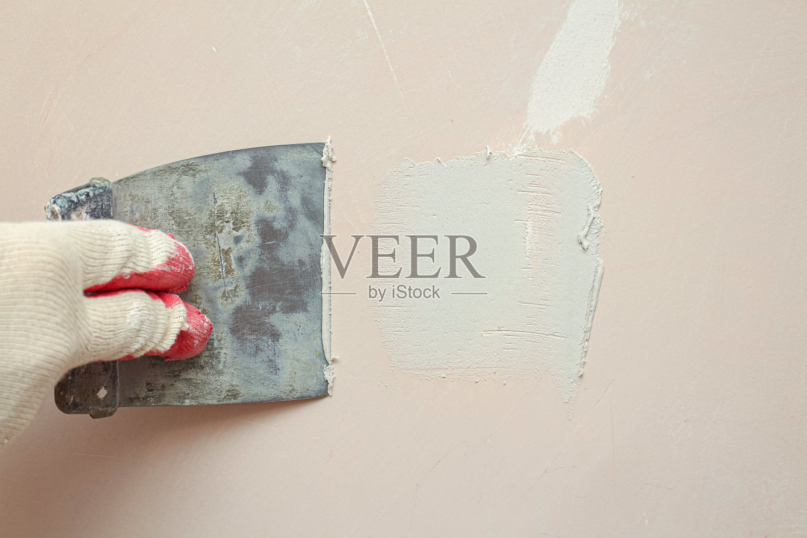 用抹刀涂抹石膏，密封裂缝。墙修复受损。照片摄影图片