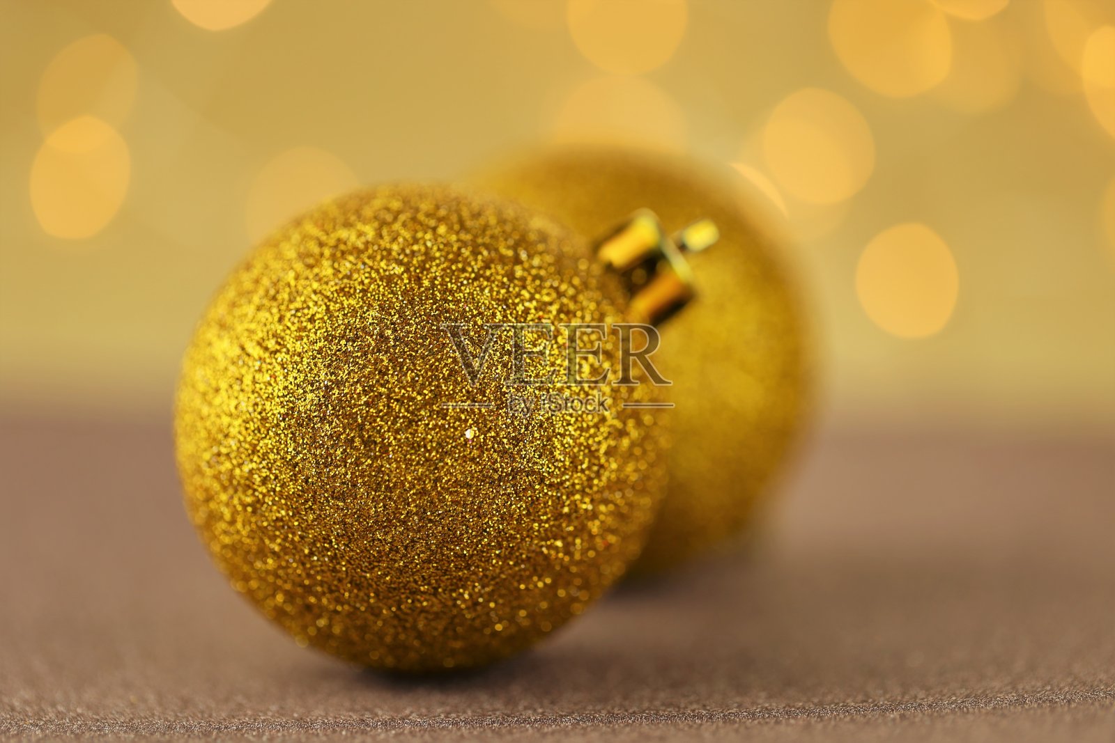 圣诞和新年的喜庆背景。金色闪闪发光的圣诞球在结合的棕色和金色背景与散景。漂亮的亮壁纸。照片摄影图片