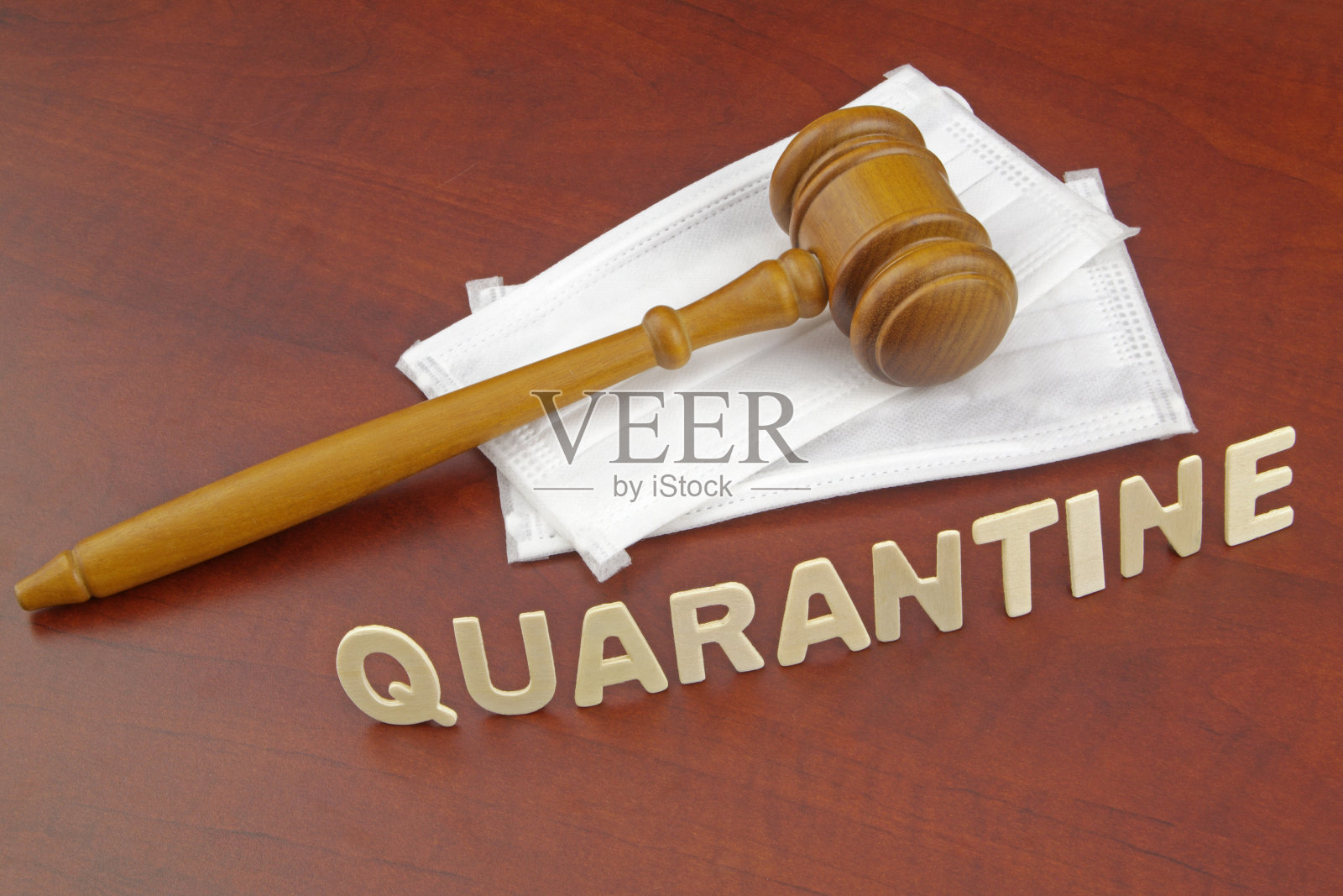 带有医用口罩和隔离字样的木制法官 gavel照片摄影图片