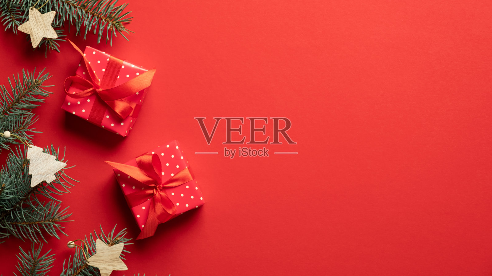 圣诞礼物和冷杉枝在红色背景与复制空间。圣诞横幅模型，贺卡模板。平躺，俯视图。照片摄影图片