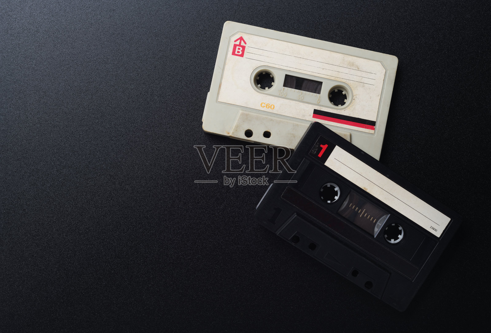 两盒黑白的老式磁带，黑色背景，俯视图。照片摄影图片