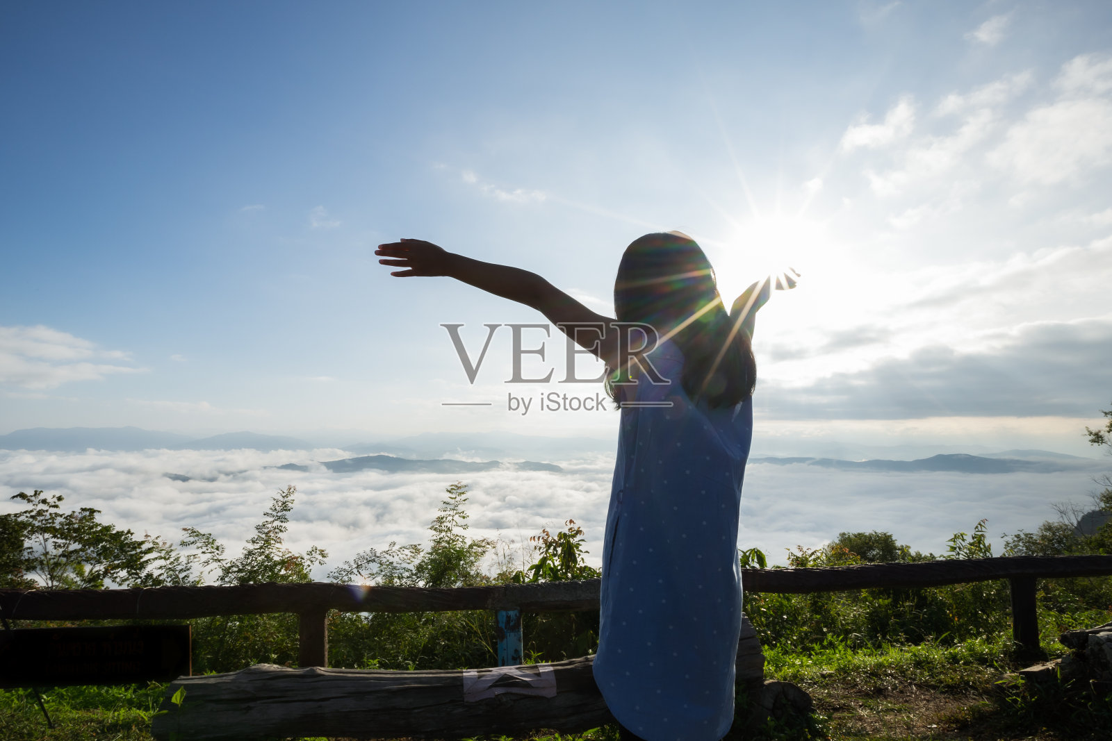 亚洲小女孩举起双臂，望着美丽的雾和山，享受着美丽的自然和清新和幸福照片摄影图片