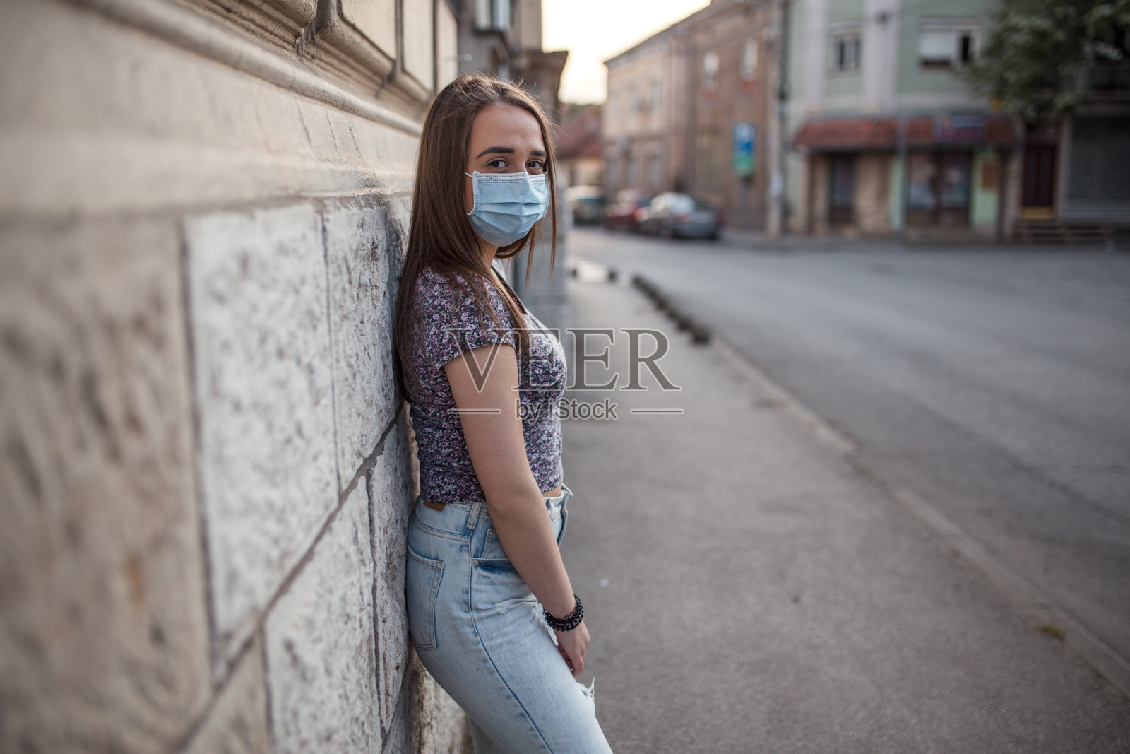 美丽的年轻女子戴着防护面具在城市街道上照片摄影图片