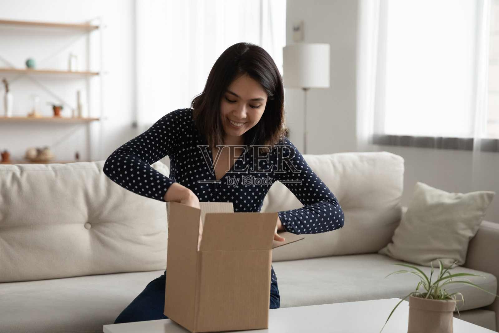快乐的亚洲女人打开网购的盒子照片摄影图片