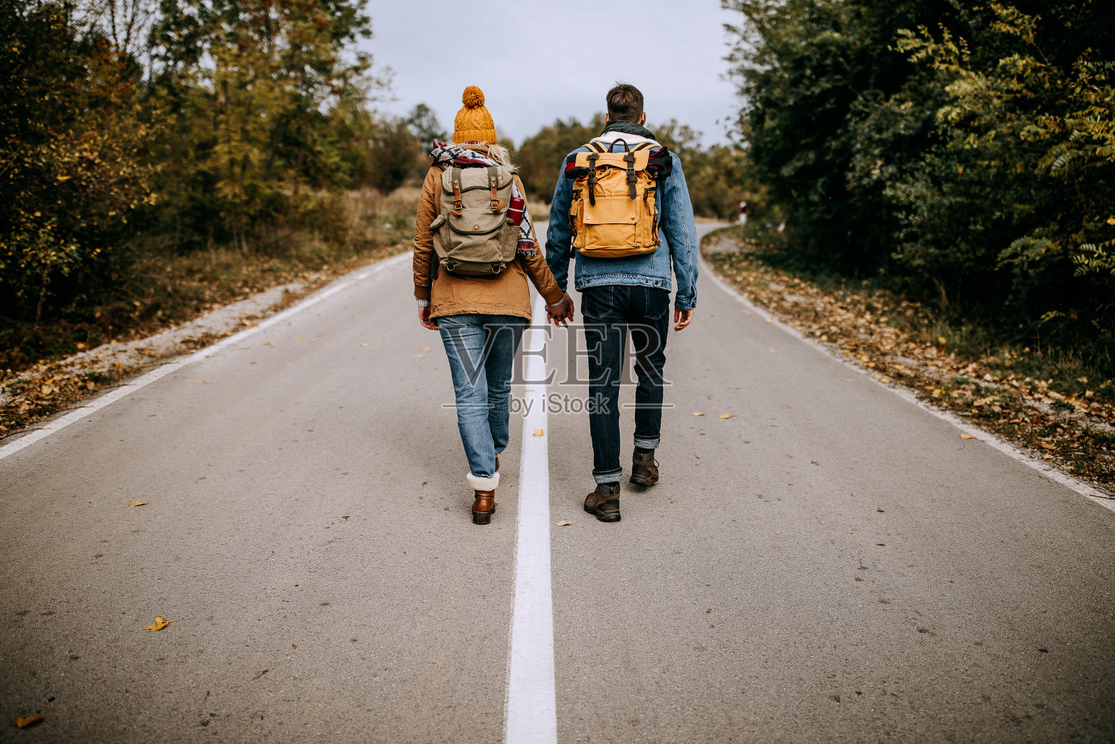 一对年轻的徒步旅行者在乡间小路上照片摄影图片