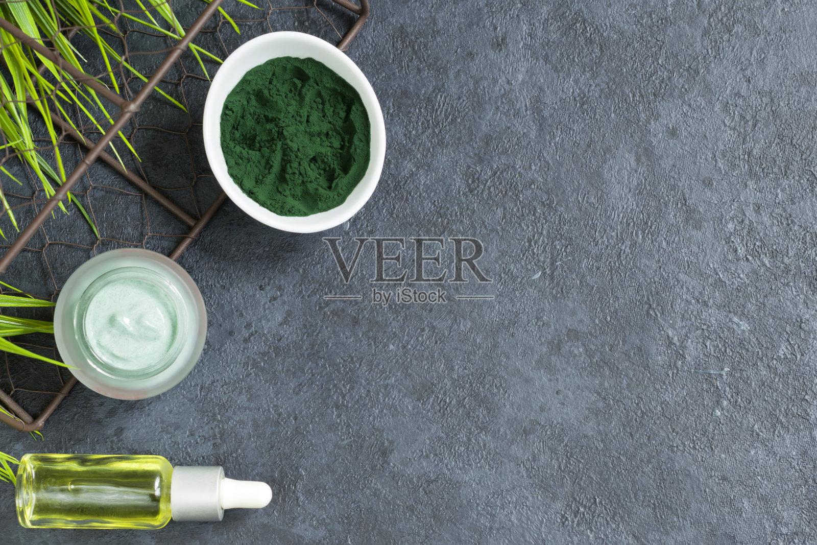 螺旋藻粉在深色背景上。用于水疗和美容的天然成分。用于脸部和身体的油。天然抗氧化剂。抗衰老的效果。本空间照片摄影图片