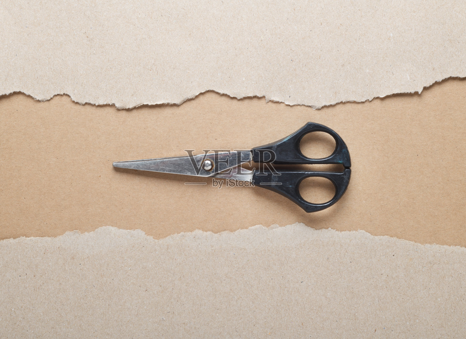 旧剪刀躺在撕破的硬纸板中间。黑色的纸，撕边孤立在黑色背景的彩色纸里面。好的纸纹理。前视图。照片摄影图片