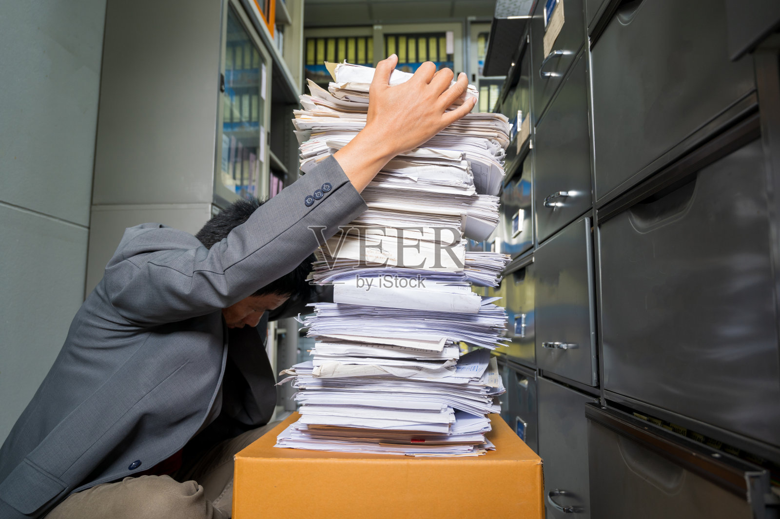 商务男人在办公室被文件压得烦恼照片摄影图片