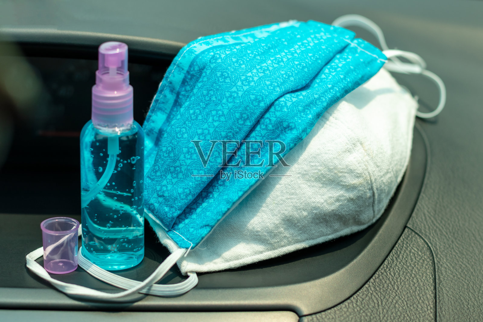 布口罩和一瓶凝胶在车里。照片摄影图片