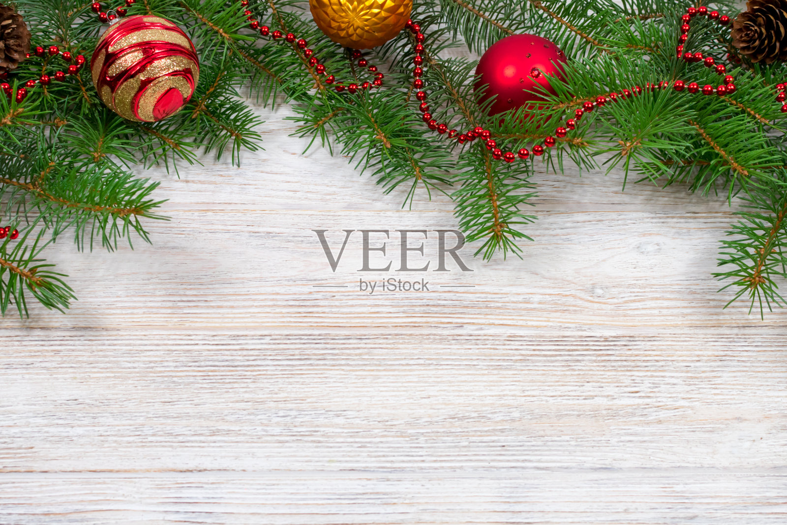 女人手里拿着一杯茶和饼干，放在有圣诞树和装饰品的木桌上照片摄影图片