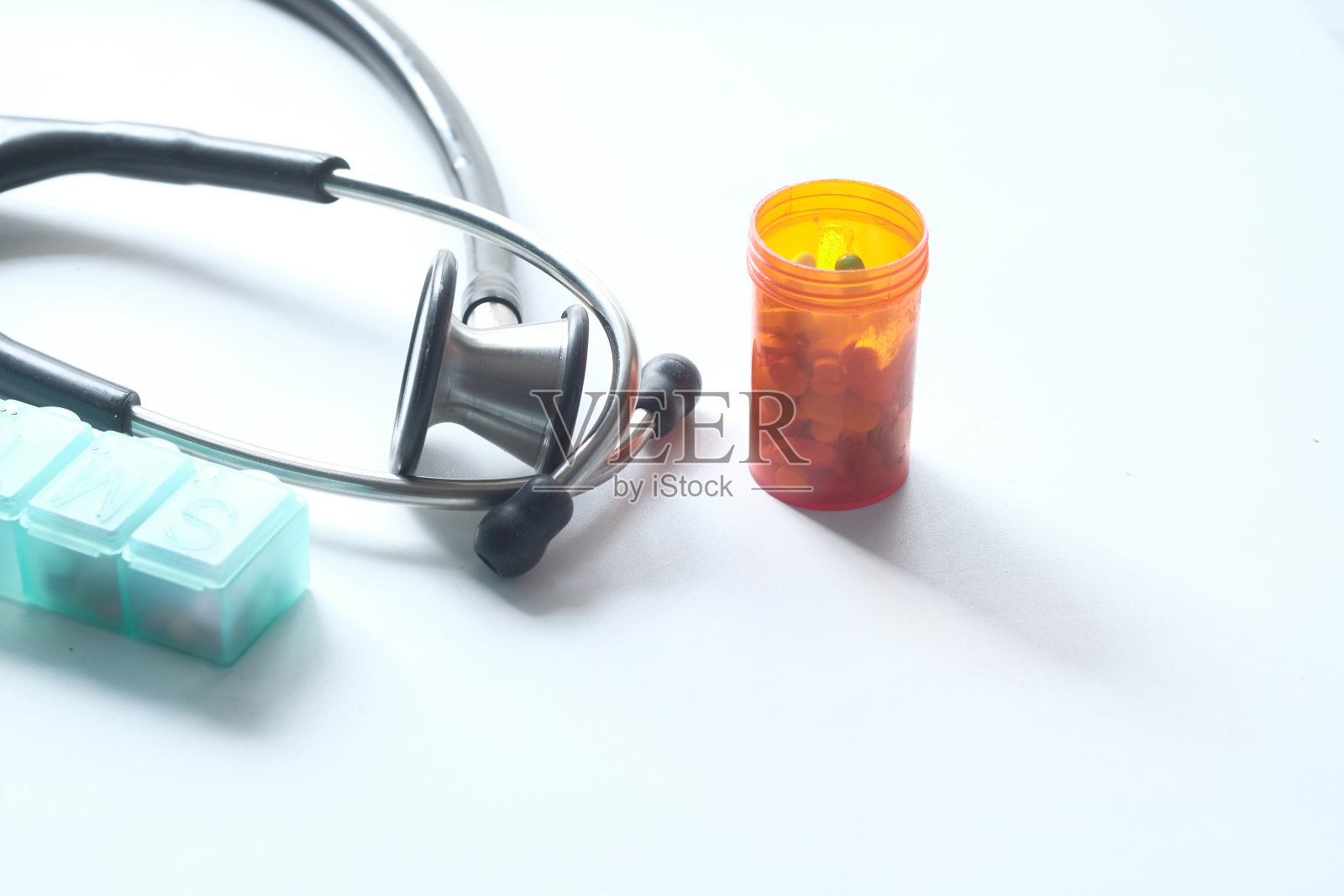 听诊器和药片容器的白色背景照片摄影图片