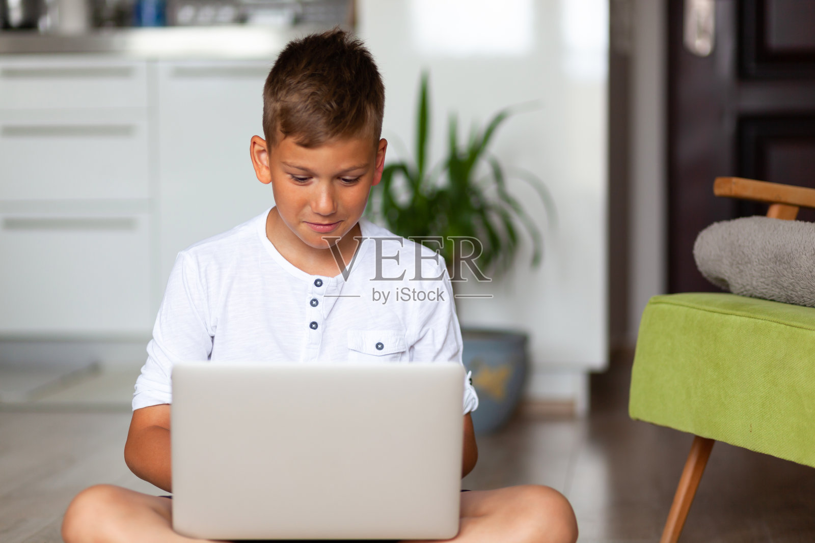在客厅使用笔记本电脑的微笑男孩照片摄影图片