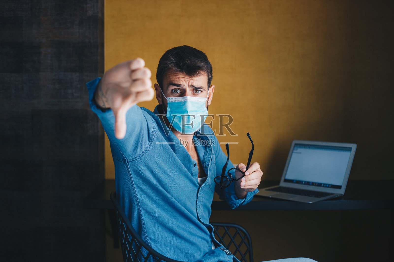 一个年轻的自由职业者正在表现他的不满。冠状病毒意识。照片摄影图片