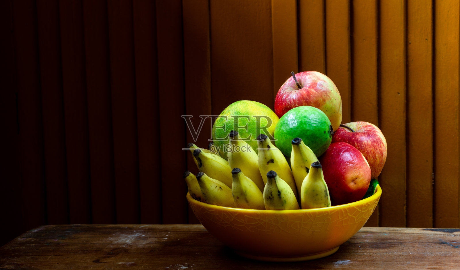 木桌上放着一碗水果照片摄影图片