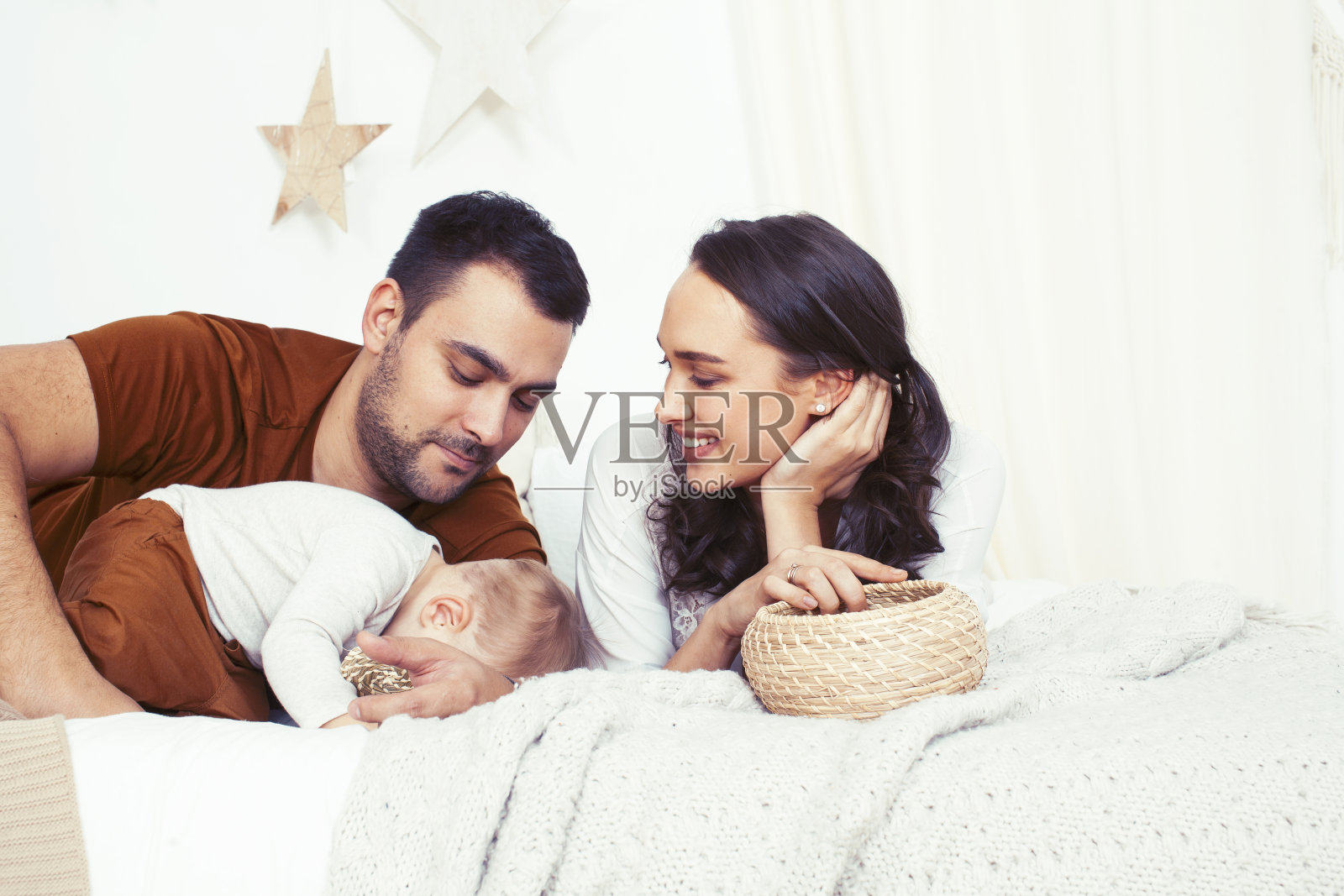 年轻幸福的家庭一起在床上嬉戏，生活方式让人概念照片摄影图片