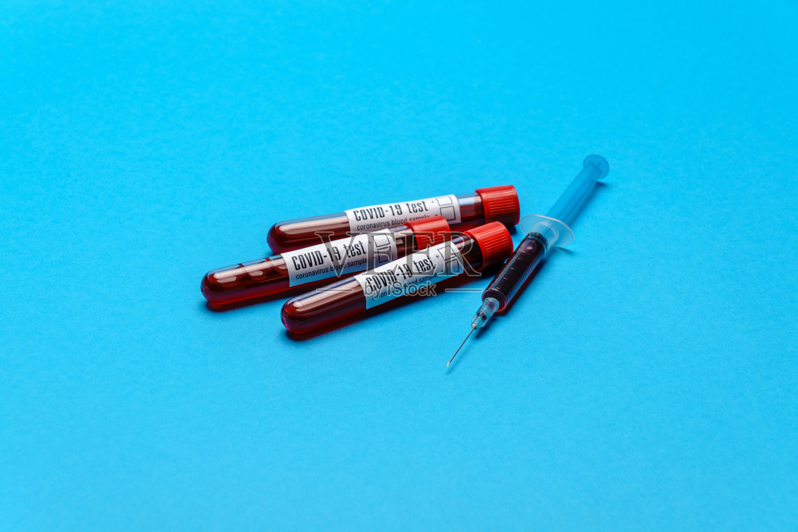 带有血液样本的注射器和塑料试管，蓝色背景，带有拷贝空间照片摄影图片